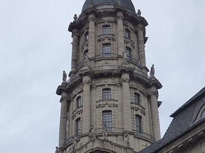 Old City Hall  An imposing external feature of the building is the tower, approximately 80 metres (260 ft) tall,[9] which rises from a square base over the central bay facing Judenstraße. Inspired by those designed by Carl von Gontard for the French and German Cathedrals on the Gendarmenmarkt,[9][10] it consists of a double set of cylinders with encircling columns,.[3] This structure is surmounted by a dome on which a 3.25 metres (10.7 ft) copper sculpture of the goddess Fortuna, by Ignatius Taschner, stands on a gilded globe.[8][11] It was originally intended to show that Berlin "is taking an upward path in its development".