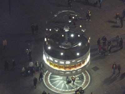 The World Clock  The World Clock (German: Weltzeituhr), also known as the Urania World Clock (German: Urania-Weltzeituhr) is a large turret-style world clock located in the public square of Alexanderplatz in Mitte, Berlin. By reading the markings on its metal rotunda, the current time in 148 major cities from around the world can be determined.[1] Since its erection in 1969, it has become a tourist attraction and meeting place. In July 2015, the German government declared the clock as a historically and culturally significant monument. - viewed  from the TV Tower.