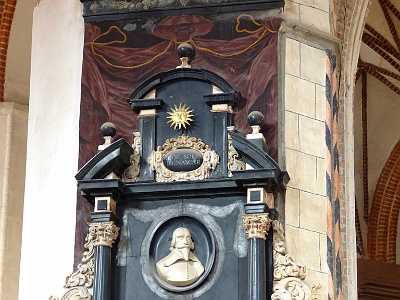 Epitaph  John Mochinger  The epitaph of the late 16th-century pastor John Mochinger, professor of rhetoric at the Academic Gymnasium. The black marble epitaph was founded by his wife Aniel, who came from the Neri family settled in Gdansk.