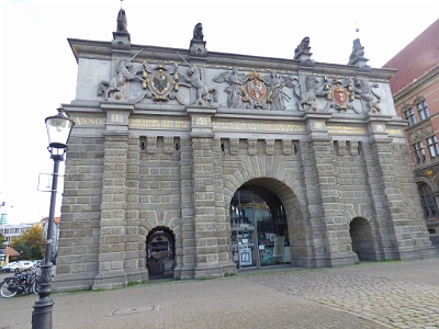 High Gate  the renaissance city ​​gate in Gdańsk , nowadays the main motorway ( Okopowa and Jagiellonian streets). Until 1895 it was in the 16th century fortifications, between Bastion St. Elżbieta and Bastion Karowy and was the main entrance gate to the city, opening the so-called Royal Road The vigorous form of the gate was to the city gates of Antwerp ( Sint-Jorispoort - St. George's Gate from 1543-45, Kipdorppoort from 1550), based on Italian designs. In the ground four replicas of the Tuscan pilasters are flanked by three semi-circular closed passages - the middle, the tallest, were designed for pedestrian traffic, two side for pedestrian traffic. This story is faced with sandstone rustic , whose strings are decorated with deep-engraved vegetable ornament. The upper story, which had to cover the raised medal of the flight, was decorated with a heraldic frieze with three strongly raised emblems : in the middle of the Commonwealth , on the right of Gdansk , on the left of Royal Prussia . The frieze is divided by flat, non-classical pilasters, which continue the vertical divisions of the lower storey and are found at the attic in the sculptures of four lions. The whole is covered with a flat hipped roof.