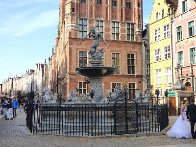 Neptune Fountain  Neptune's Fountain - is a historic fountain in Gdańsk, which was constructed with the initiative of Mayor Bartłomiej Schachmann, and the local authorities. The fountain is located in the most notable part of Gdańsk - Long Market, by the entrance to Artus Court. Formerly, the fountain was painted. The fountain was opened in October 9, 1633, the delay was caused due to numerous disruptions: the renovation of Artus Court; problems with the robustness of the water system; the Thirty Years' War; and the death of Abraham van den Blocke. The inauguration of the fountain's operation took place in March 23, 1634. Between the years of 1757 and 1761, Jan Karol Stender made new fragments of the fountain and stem, and meister blacksmith Jakub Barren had reconstructed and replaced the broken grate. This is when the fountain received its rococo architectural style