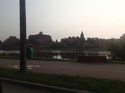 Castle from across the river  Malbork [ˈmalbɔrk] (German: Marienburg  is a town in northern Poland in the Żuławy region (Vistula delta), with 38,478 inhabitants (2006).  Founded in the 13th century by the Knights of the Teutonic Order, the town is noted for its medieval Malbork Castle, built in the 13th Century as the Order's headquarters and of what later became known as Royal Prussia. The town of Marienburg grew in the vicinity of the castle. The river Nogat and flat terrain allowed easy access for barges a hundred kilometers from the sea. During Prussia's government by the Teutonic Knights, the Order collected tolls on river traffic and imposed a monopoly on the amber trade.