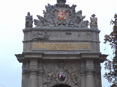 Port Gate  Port Gate - one of the city gates of Szczecin , built in Baroque style in the years 1725-1727 according to the design of Dutch architect Gerhard Cornelius van Wallrawe. It is one of the two (next to the Royal Gate ) preserved to modern times, which are the remains of the former Prussian fortifications . The exterior of the gate was decorated by the French sculptor Bartholomé Damart. There is a shield with the monogram of King Friedrich Wilhelm I , the founder of this object. In the attic a plaque with a gold inscription in Latin , which informs about the rights of the Brandenburg state to Pomerania and Szczecin, since Frederick Wilhelm in 1719 bought Szczecin from the Swedes for two million thalers. The inscription includes a panorama of the city along with the Viadrus (god of the river Odra ). Above is an oval shield with Prussian coat of arms crowned with a royal crown. In the years 1976 - 2013 inside the Port Gate was a shop with artistic products Cepelia [3] . Currently (2015) inside the Gate is a chamber theater.